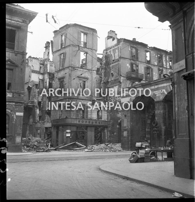 Edificio in via dell'Annunciata, all'angolo con via Alessandro Manzoni, a Milano, sventrato dai bombardamenti: al pianterreno il negozio Sopransi che vendeva fiori freschi. Sulla destra gli archi di Porta Nuova medievale