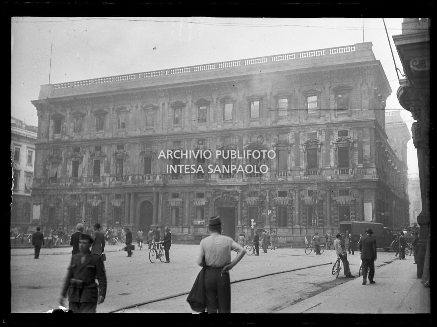 Palazzo Marino a Milano colpito gravemente dai bombardamenti aerei, ancora fumante, durante l'intervento dei vigili del fuoco