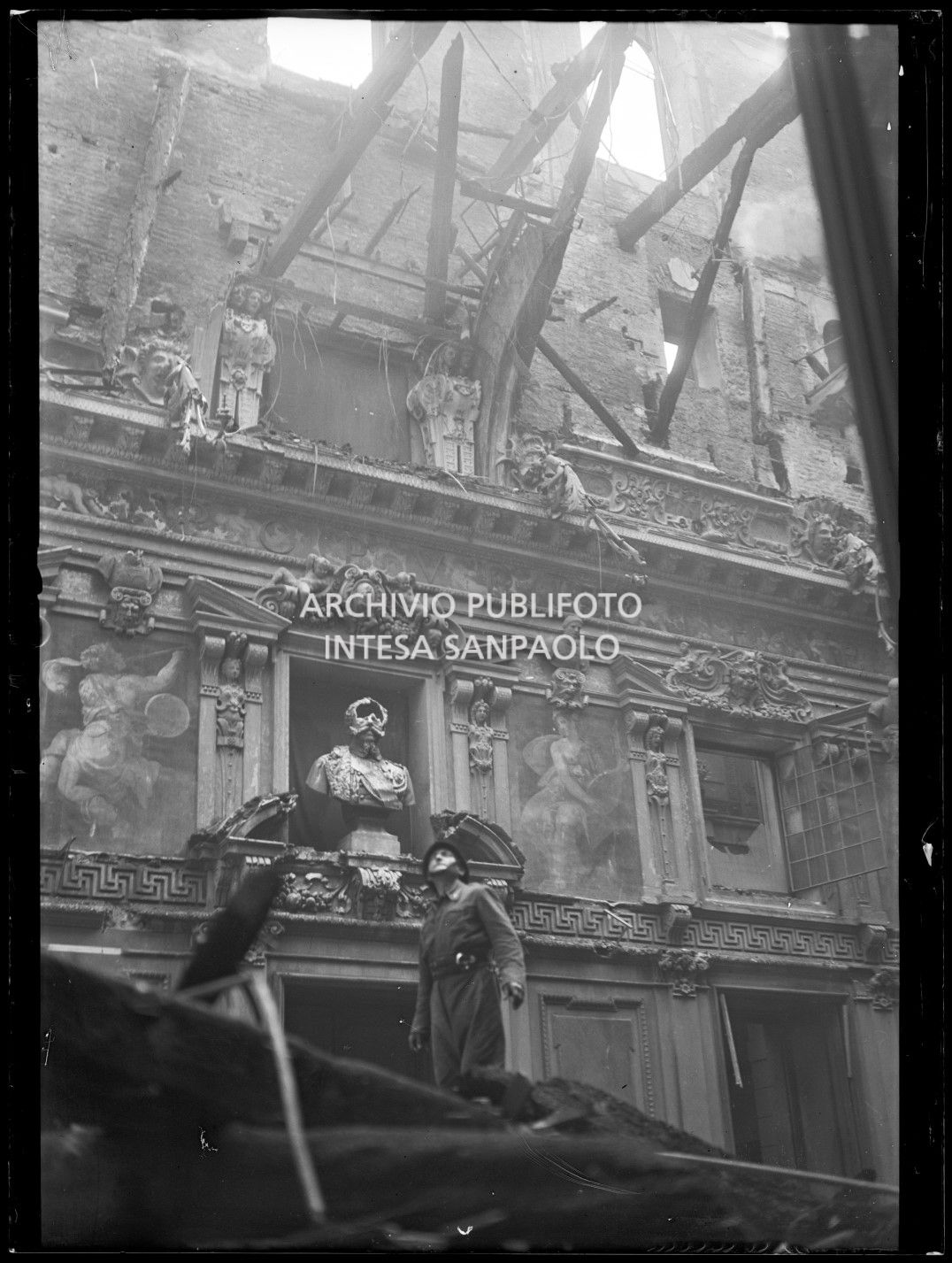 Un vigile del fuoco osserva i gravissimi danni al salone dell'Alessi di Palazzo Marino a Milano, causati dall'incendio divampato in seguito ai bombardamenti sulla città