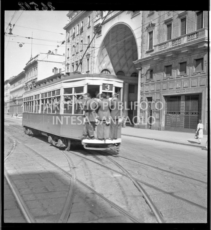 Tram tipo 1928, linea 3, in transito in corso Venezia a Milano; la vettura è così affollata che alcuni passeggeri viaggiano in piedi sul paraurti posteriore (dipinto di bianco per aumentarne la visibilità durante l'oscuramento)