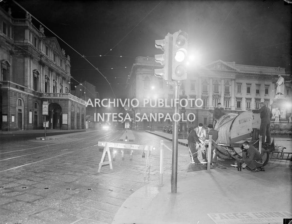 Workers from SIRTI (Società Italiana Reti Telefoniche Interurbane, Italian Association of Interurban Telephone Networks) lay coaxial cables in piazza della Scala in Milan