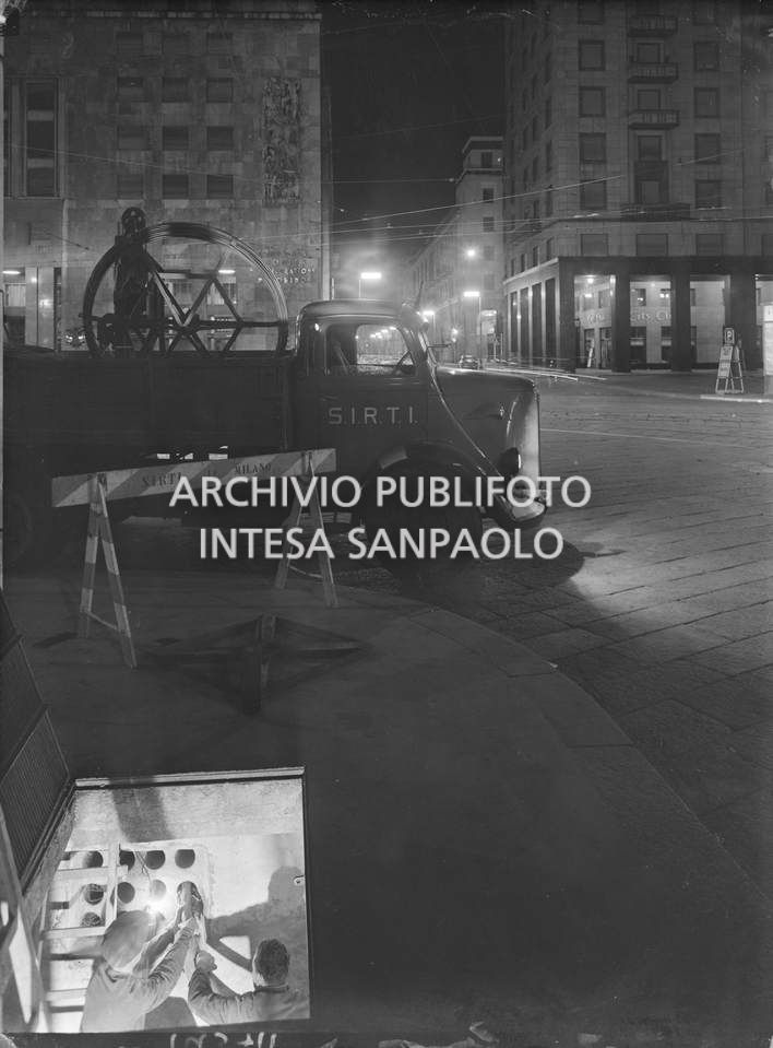 Operai della SIRTI (Società Italiana Reti Telefoniche Interurbane) posano,  di notte, cavi coassiali in piazza San Babila a Milano