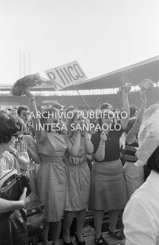 Tre sostenitrici di Ringo Starr con un cartello a lui dedicato tra il pubblico al concerto pomeridiano dei Beatles al Vigorelli di Milano