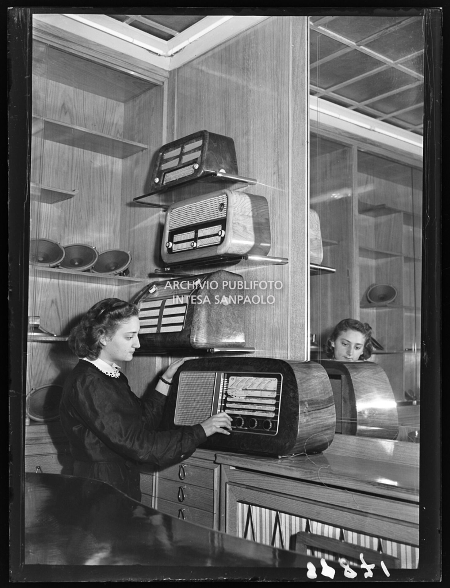 Una commessa mostra il funzionamento di una radio in un negozio alla stazione di Milano