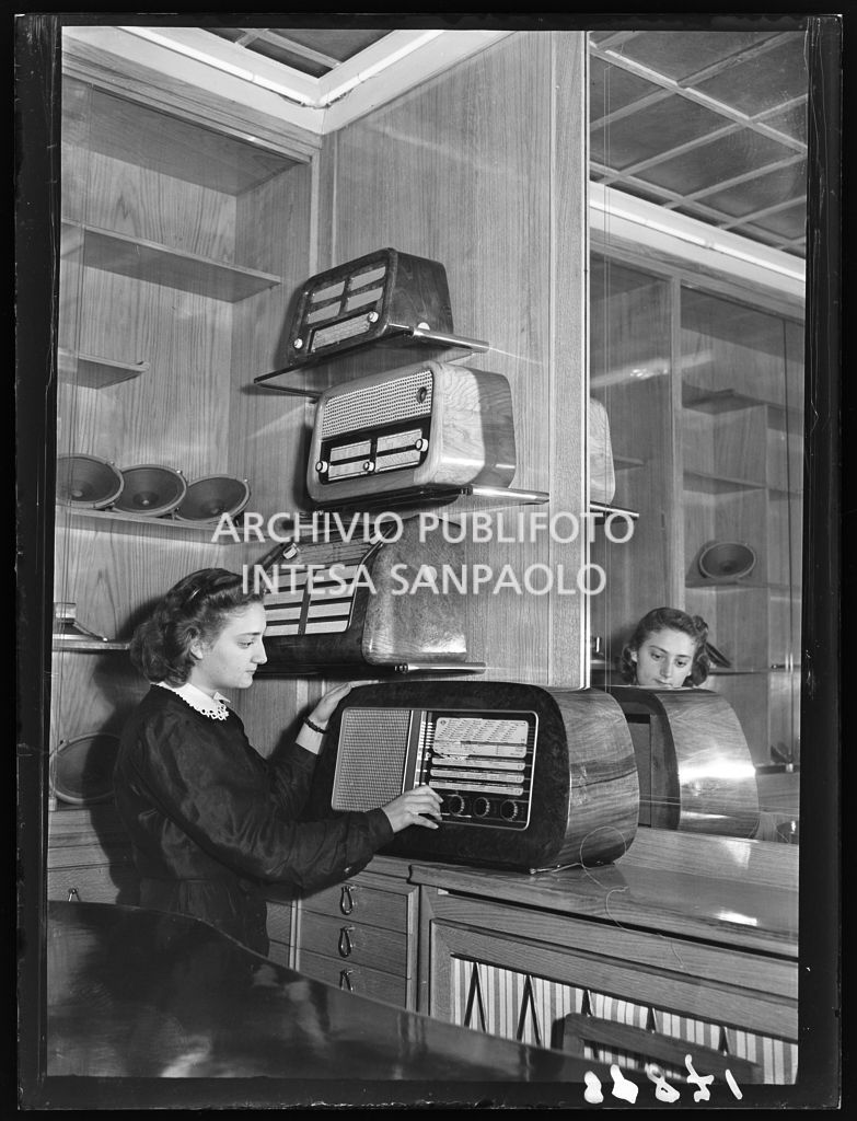 A sales assistant displays the radios on sale in a shop at the railway station of Milan