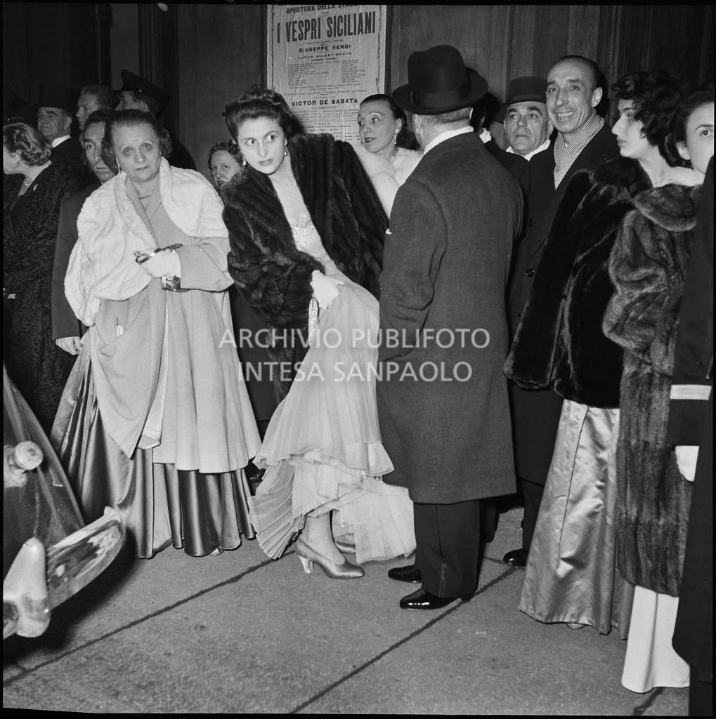 Spettatori all'esterno del Teatro alla Scala, nella galleria delle carrozze, la sera dell'inaugurazione della stagione lirica 1951-1952 con l'opera "I vespri siciliani" di Giuseppe Verdi, diretta da Victor de Sabata, con la regia di Herbert Graf