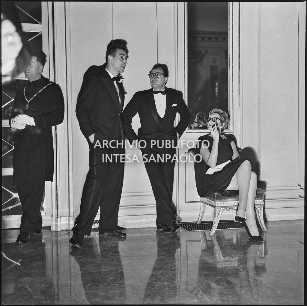 Renata Merviani con altri due spettatori nel foyer del Teatro alla Scala in occasione della serata inaugurale della stagione lirica 1958-1959 con l'opera "Turandot" di Giacomo Puccini, diretta da Antonino Votto, con la regia di Margherita Walmann