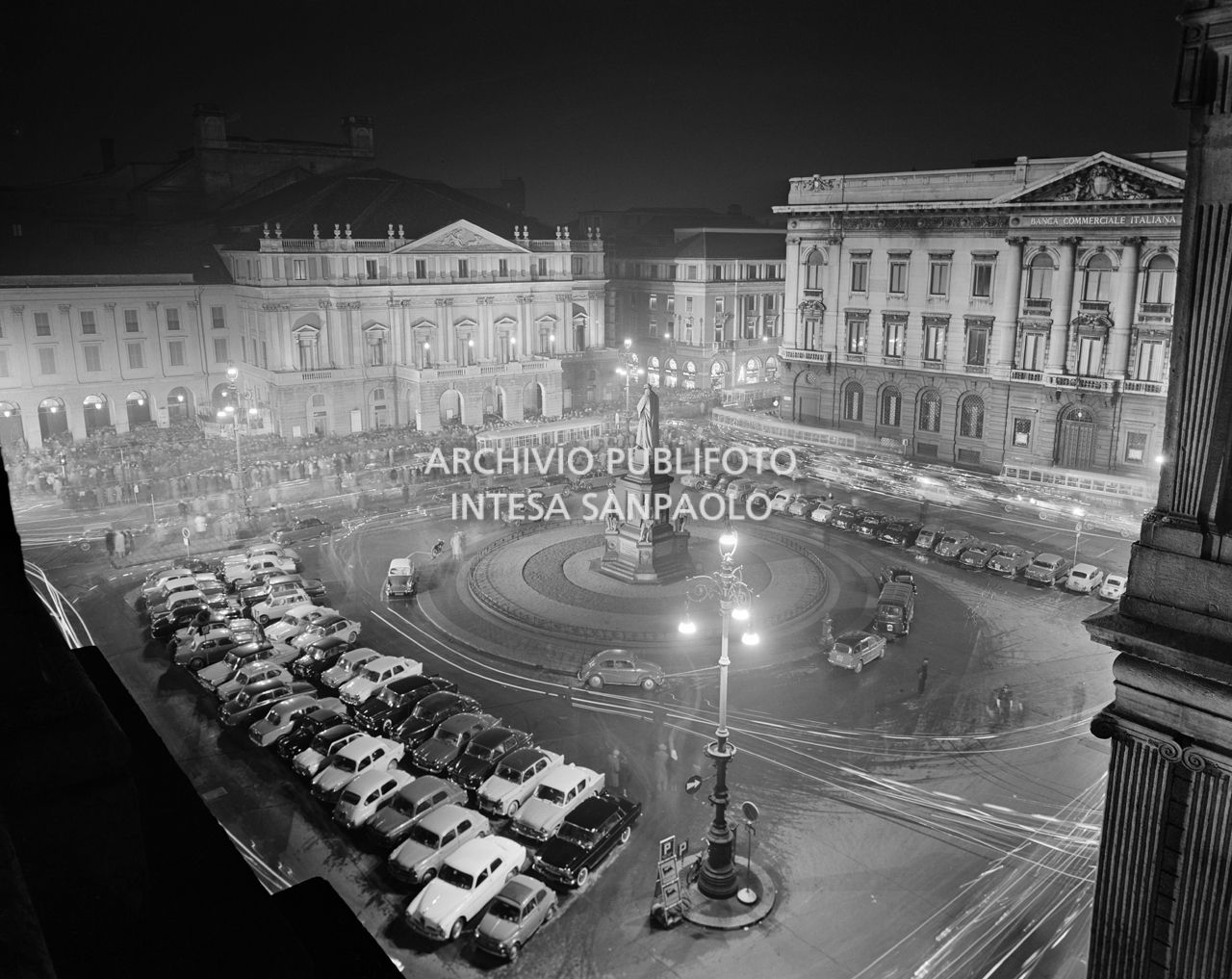 Ripresa dall'alto di piazza della Scala, con il pubblico accalcato all'entrata, la sera dell'inaugurazione della stagione lirica 1960-1961