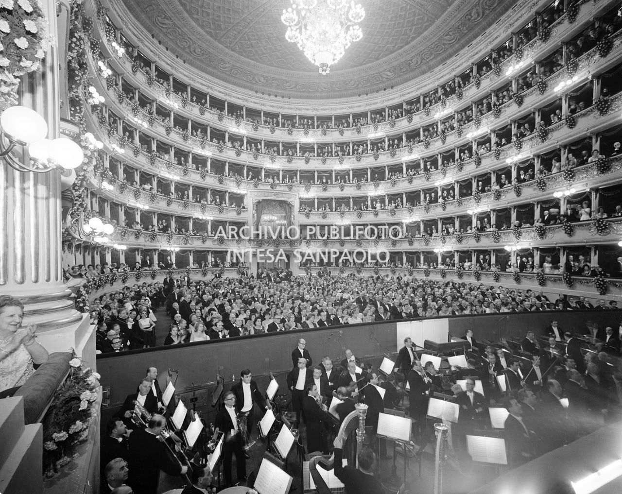 Ripresa dal palcoscenico della sala del Teatro alla Scala, con il pubblico, e in primo piano l'orchestra nel golfo mistico, la sera dell'inaugurazione della stagione lirica1965-1966 con l'opera "La forza del destino", di Giuseppe Verdi, diretta da Gianandrea Gavazzeni, con la regia di Margherita Wallmann