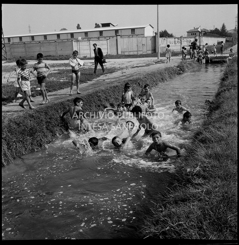 Children take a dip in a canal on the outskirts of Milan