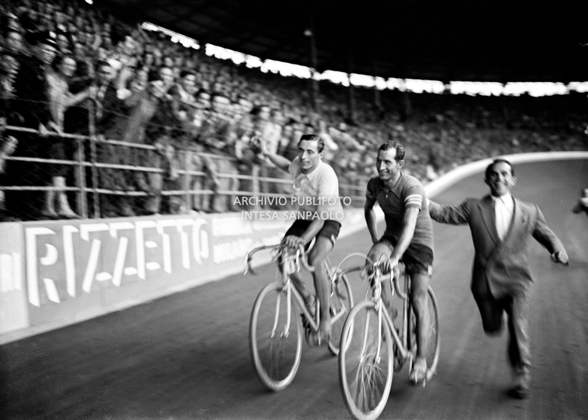 Fausto Coppi wins the 30° Giro d'Italia and completes a lap of honour with Gino Bartali at the Vigorelli velodrome of Milan