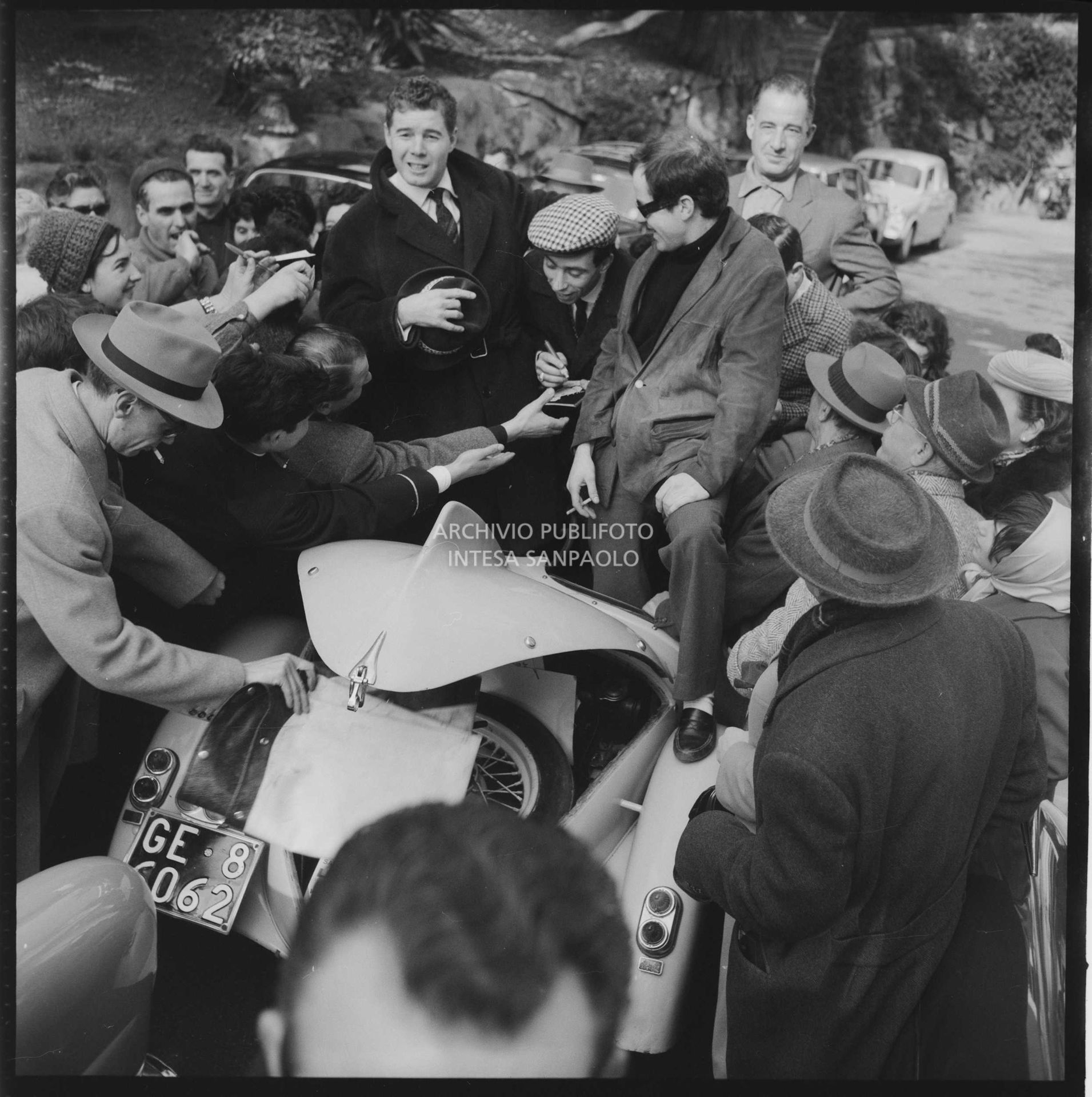 Umberto Bindi signs autographs during the 11th  Sanremo Festival; next to him Joe Sentieri (left) and Gino Paoli (right)