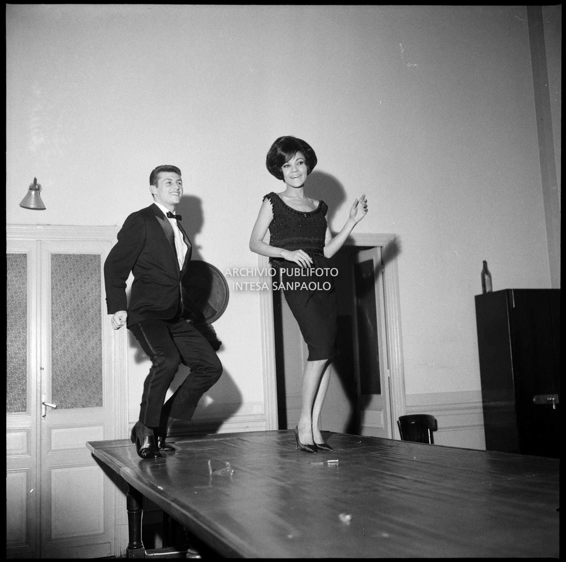 Tony Renis and Marina Moran dance on a table during a break at the 14th Sanremo Festival