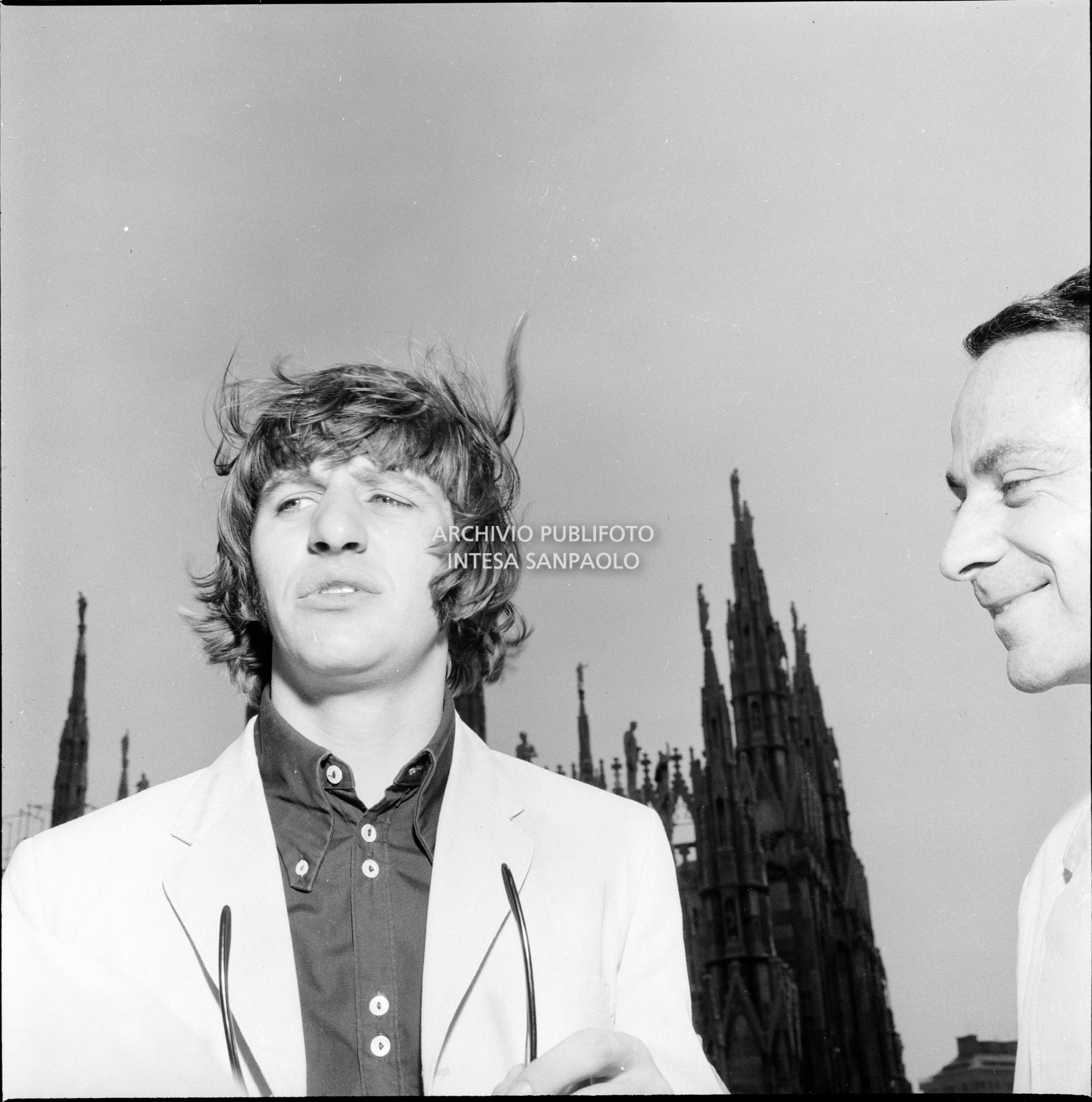 Ringo Starr ritratto sulla terrazza del Grand Hotel Duomo a Milano; sullo sfondo le guglie della cattedrale