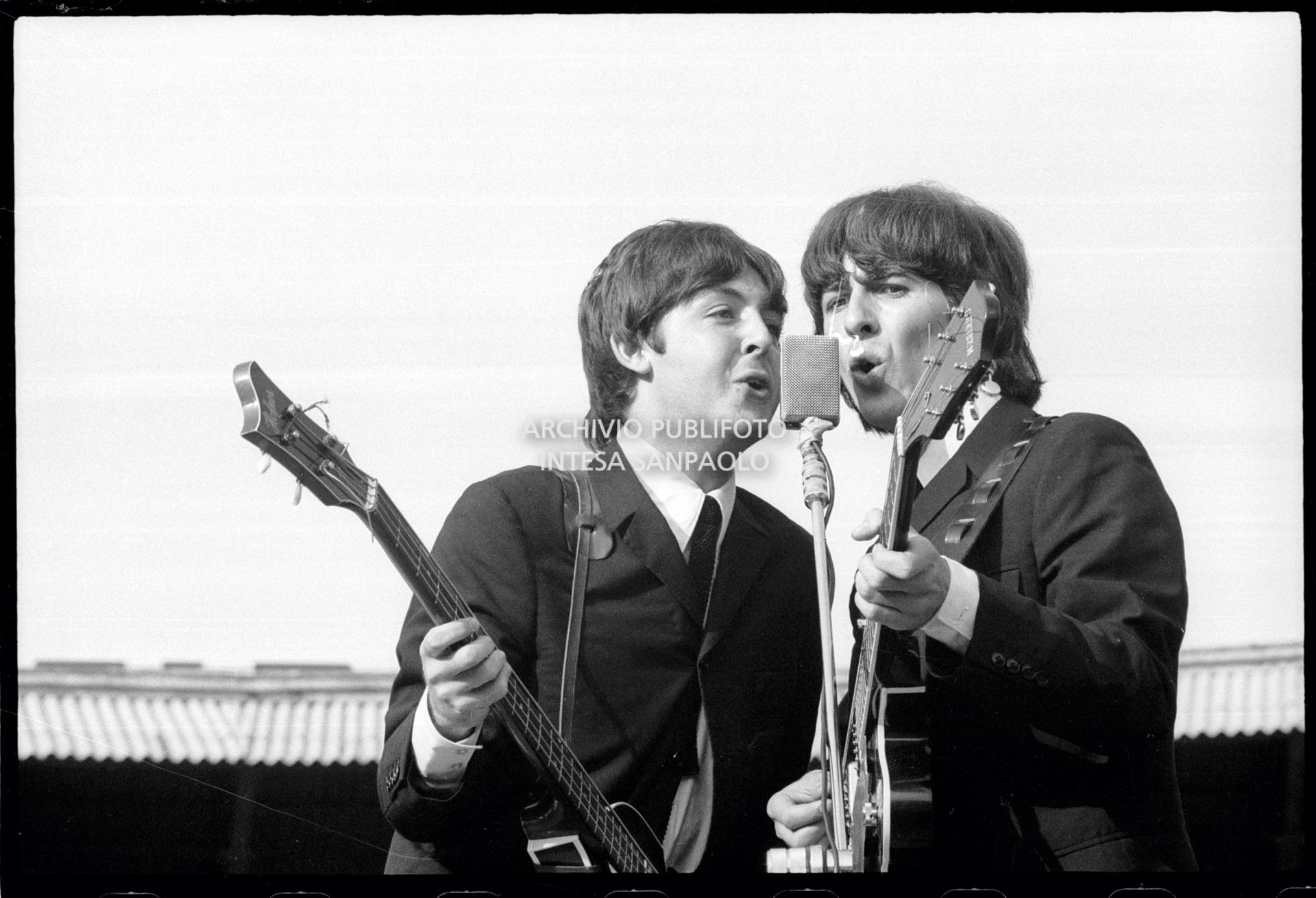 I Beatles in concerto al Vigorelli di Milano: Paul McCartney e George Harrison insieme al microfono con gli strumenti musicali