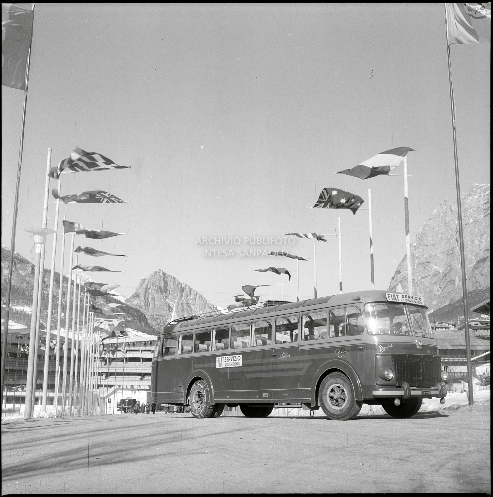 A Fiat bus, used to transport staff working at the 7th Winter Olympic Games, in the road leading to the Ice Stadium