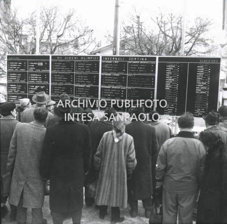 Crowd in front of the panels displaying the roll of honour of the 7th Winter Olympic Games in Cortina d'Ampezzo