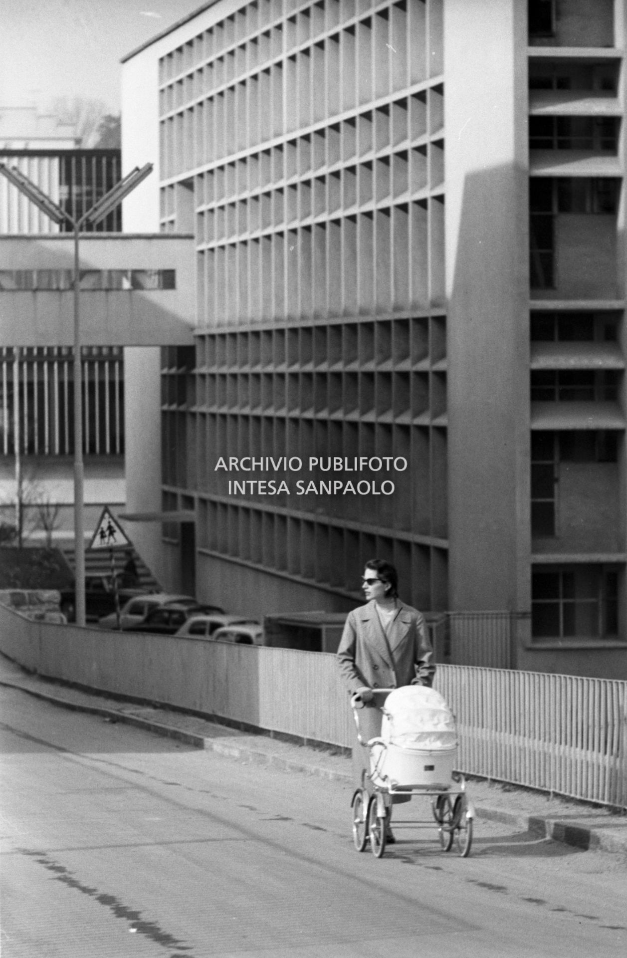 Una donna spinge una carrozzina tra gli edifici industriali della Olivetti