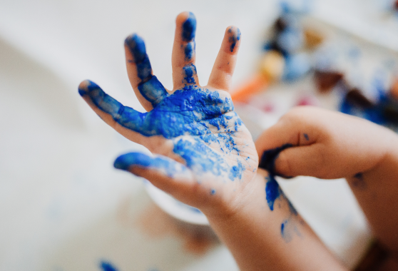 Immagini di mani di bambino con vernice colorata