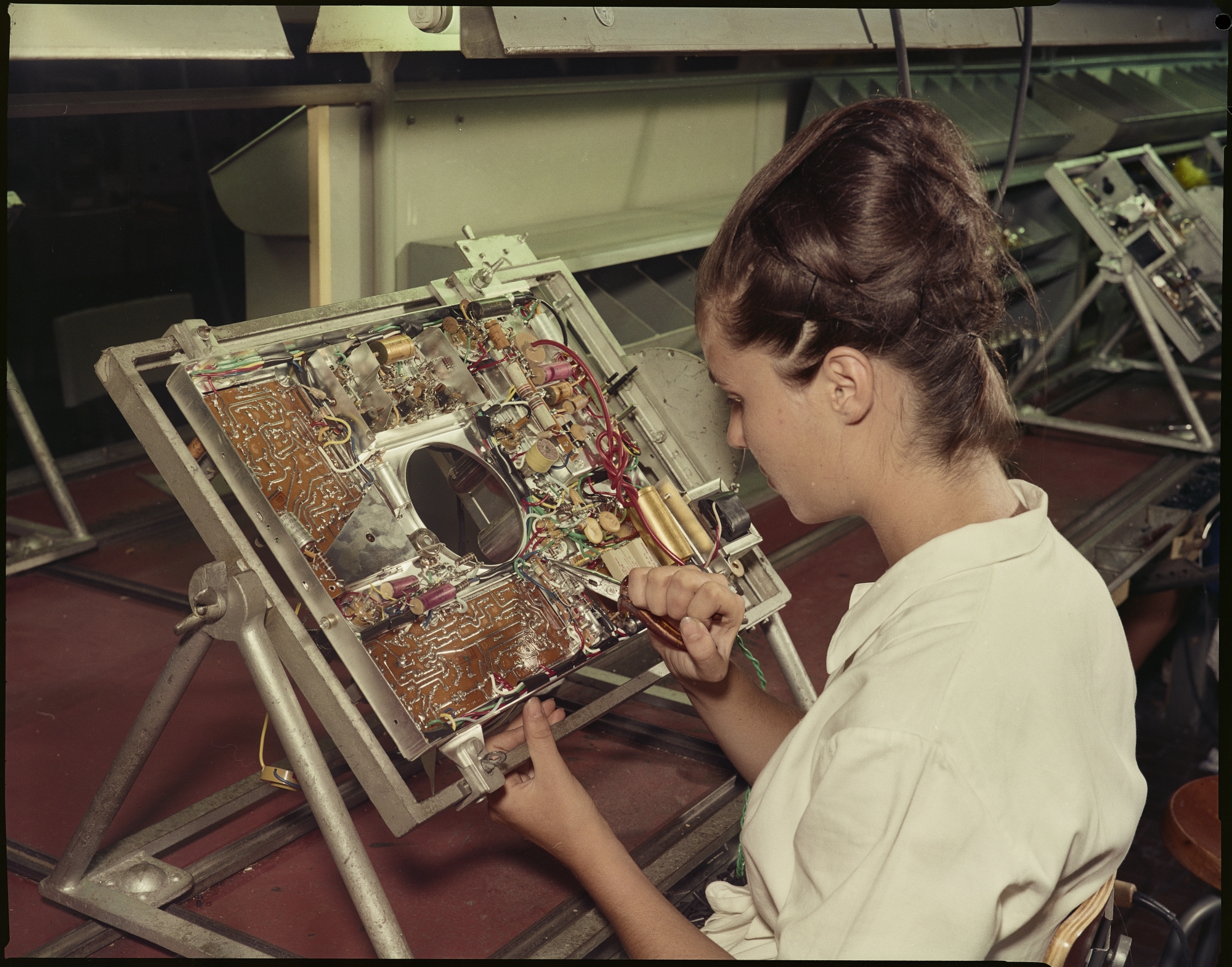 Factory worker busy with the components of a television set at the Emerson factory in Florence, 1961
